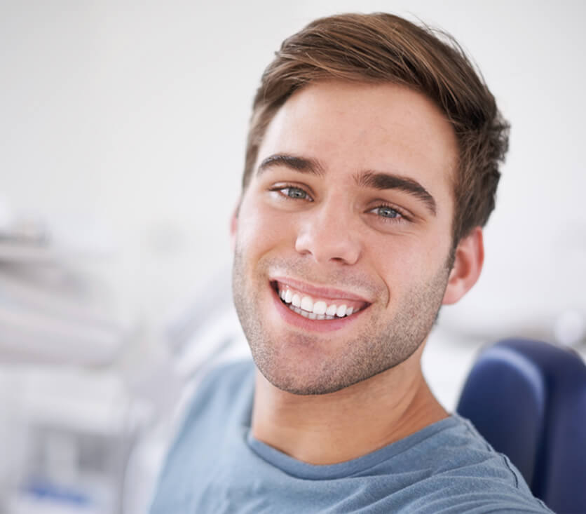 smiling man sitting in a dental chair